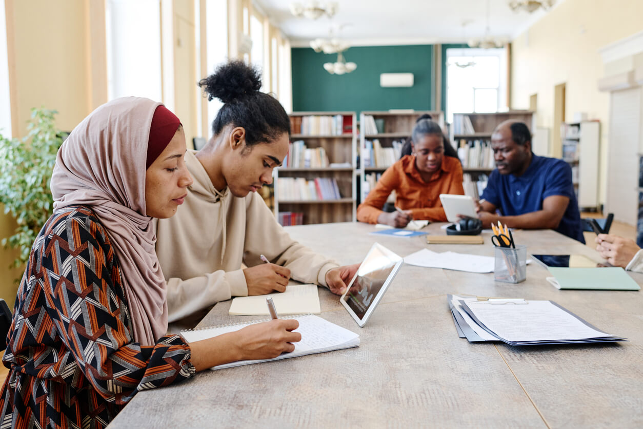 four people studying in a library