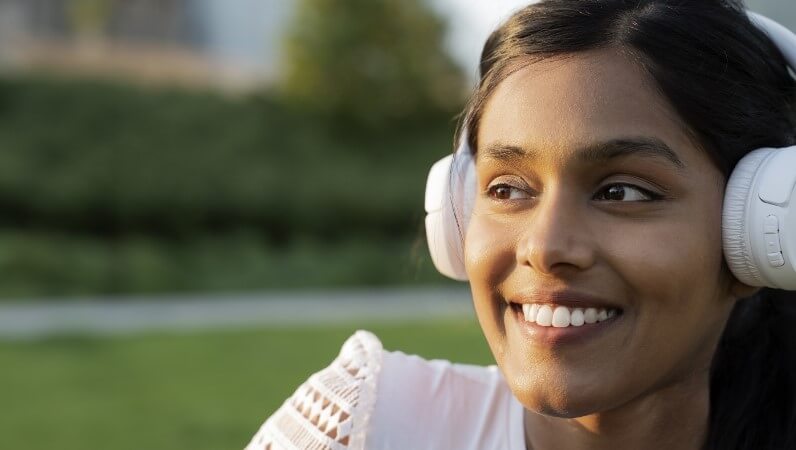 Woman smiling, wearing headphones