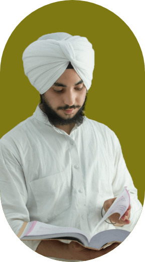 Man in a turban and white shirt, reading a notebook