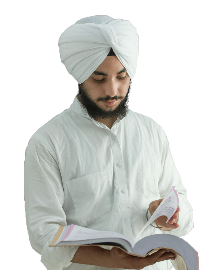 Man in a turban and white shirt, reading a notebook